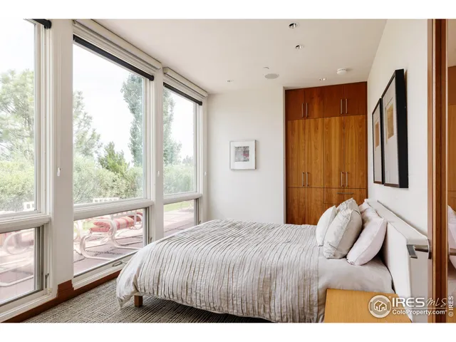 a bedroom with a bed and a large window