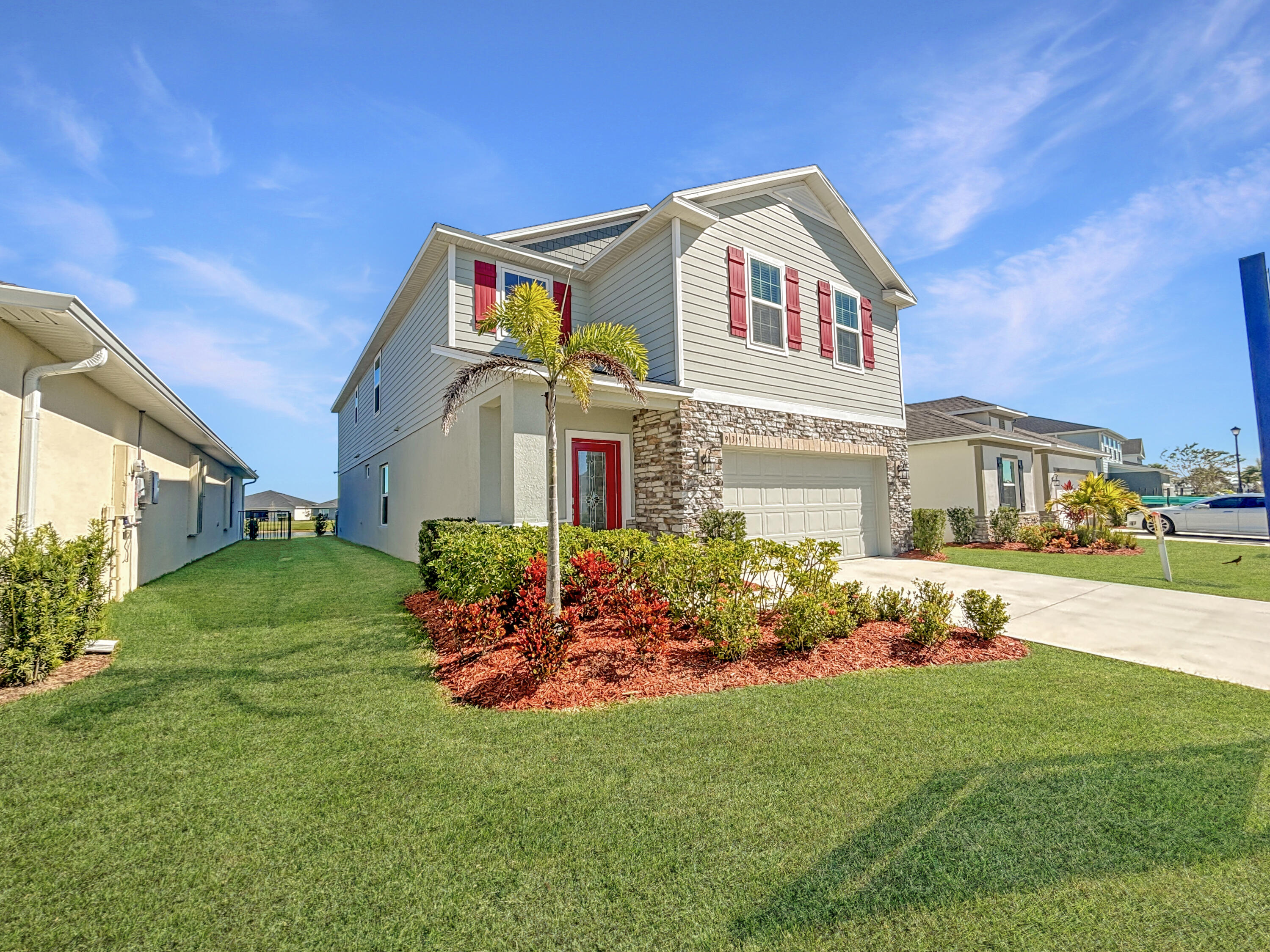 a front view of a house with a big yard and potted plants