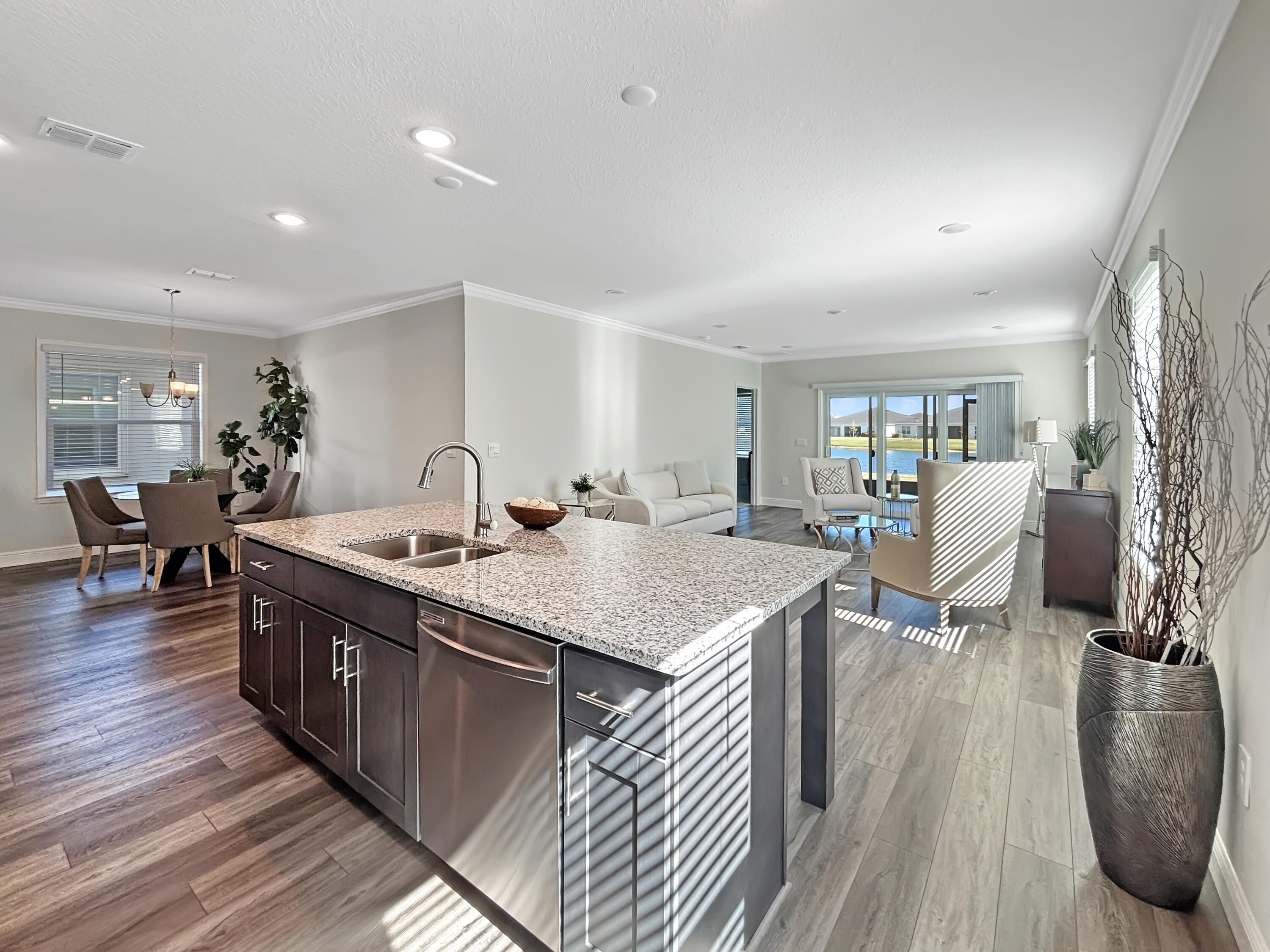 9399 Southwest Serapis Way Port Port St. Lucie, FL 34987 - Photo 12 of 43 a large kitchen with stainless steel appliances granite countertop a lot of counter space and wooden floors