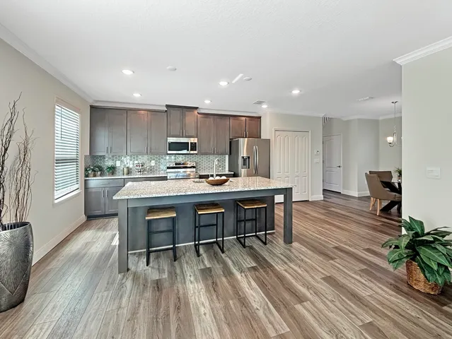 a open kitchen with kitchen island white cabinets and stainless steel appliances