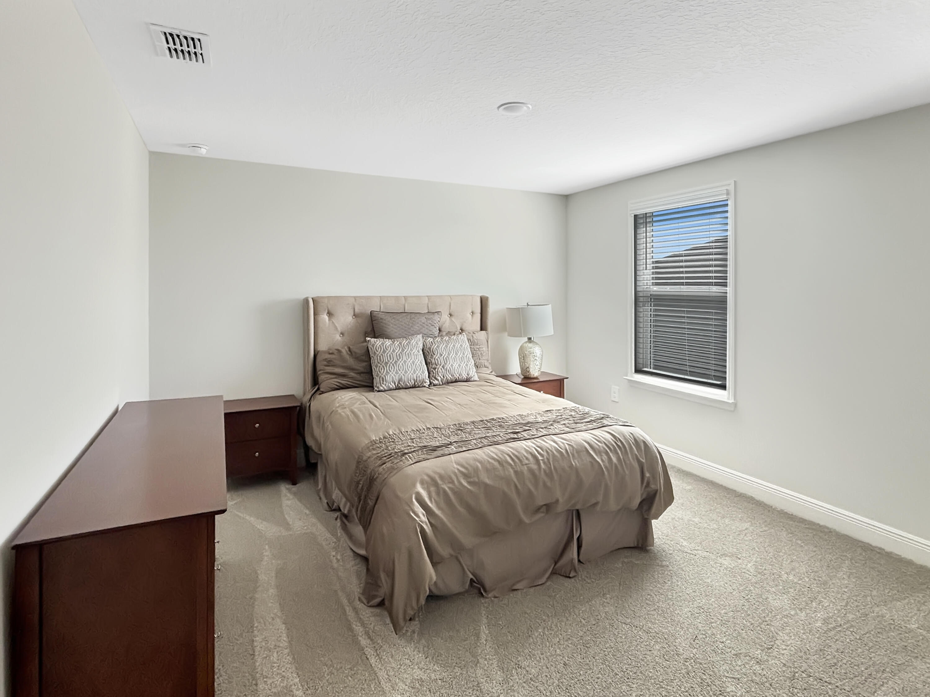 9399 Southwest Serapis Way Port Port St. Lucie, FL 34987 - Photo 19 of 43 a bedroom with a bed and a window