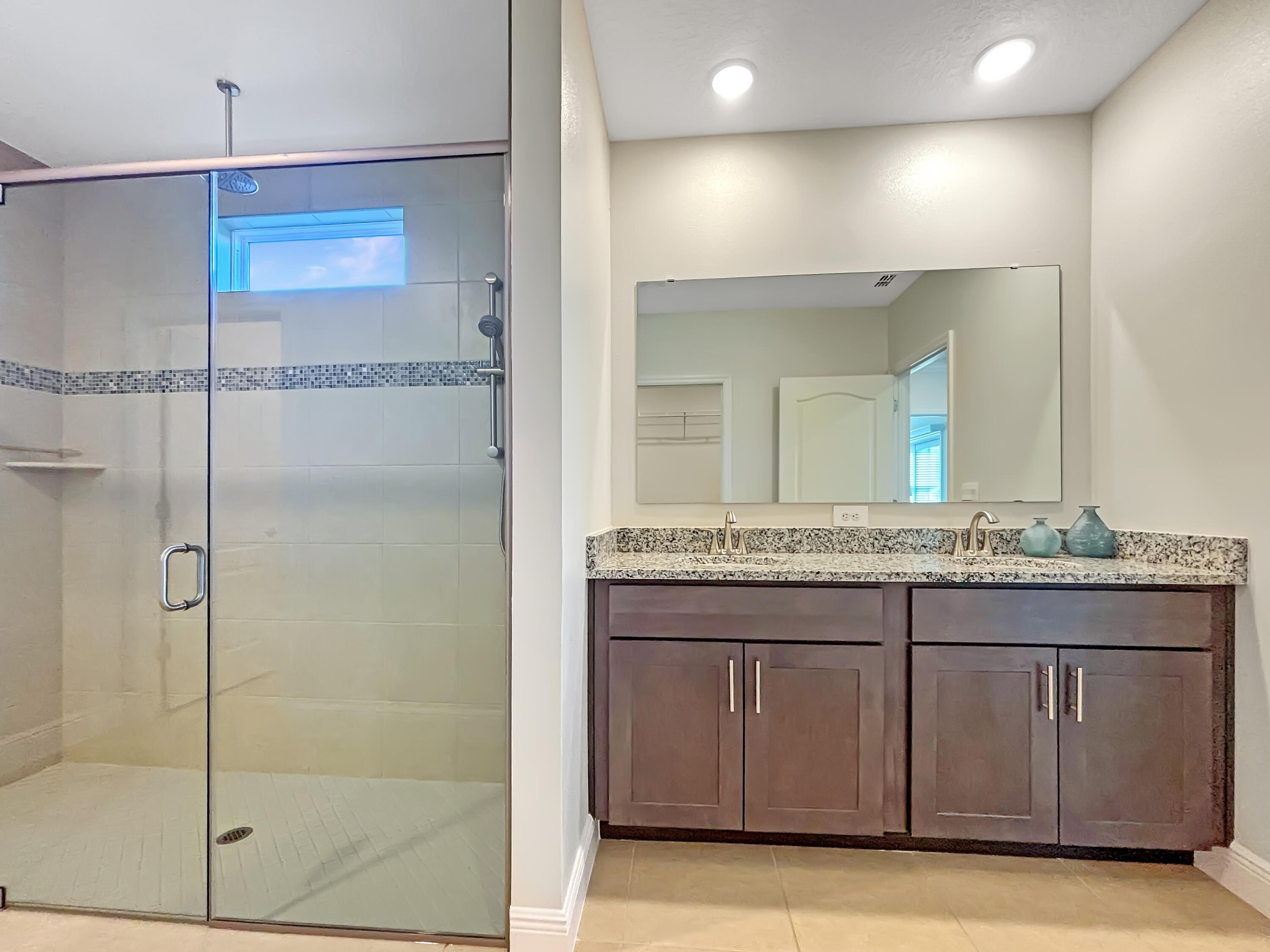 9399 Southwest Serapis Way Port Port St. Lucie, FL 34987 - Photo 20 of 43 a bathroom with a granite countertop sink a mirror and a shower