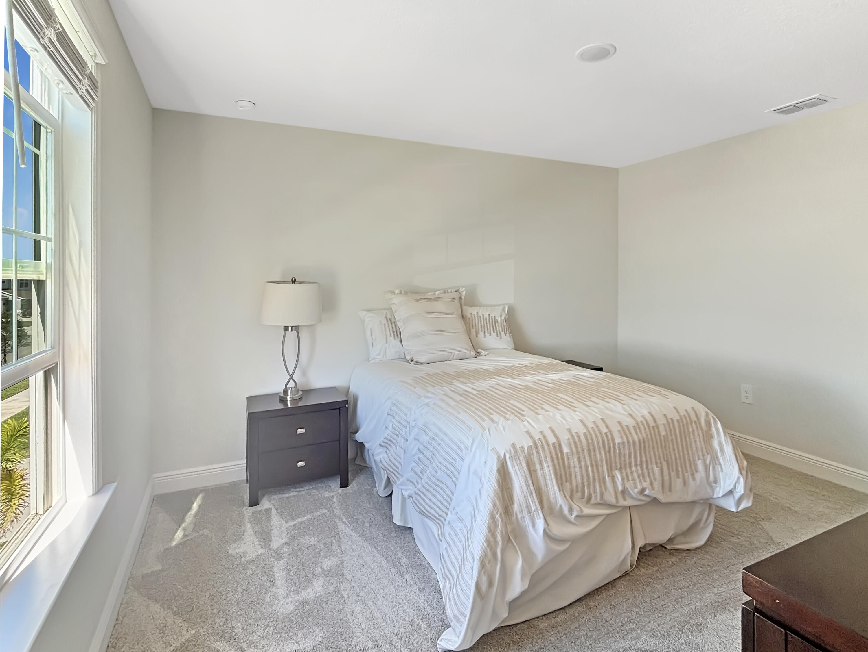 9399 Southwest Serapis Way Port Port St. Lucie, FL 34987 - Photo 21 of 43 a bedroom with a bed and a window
