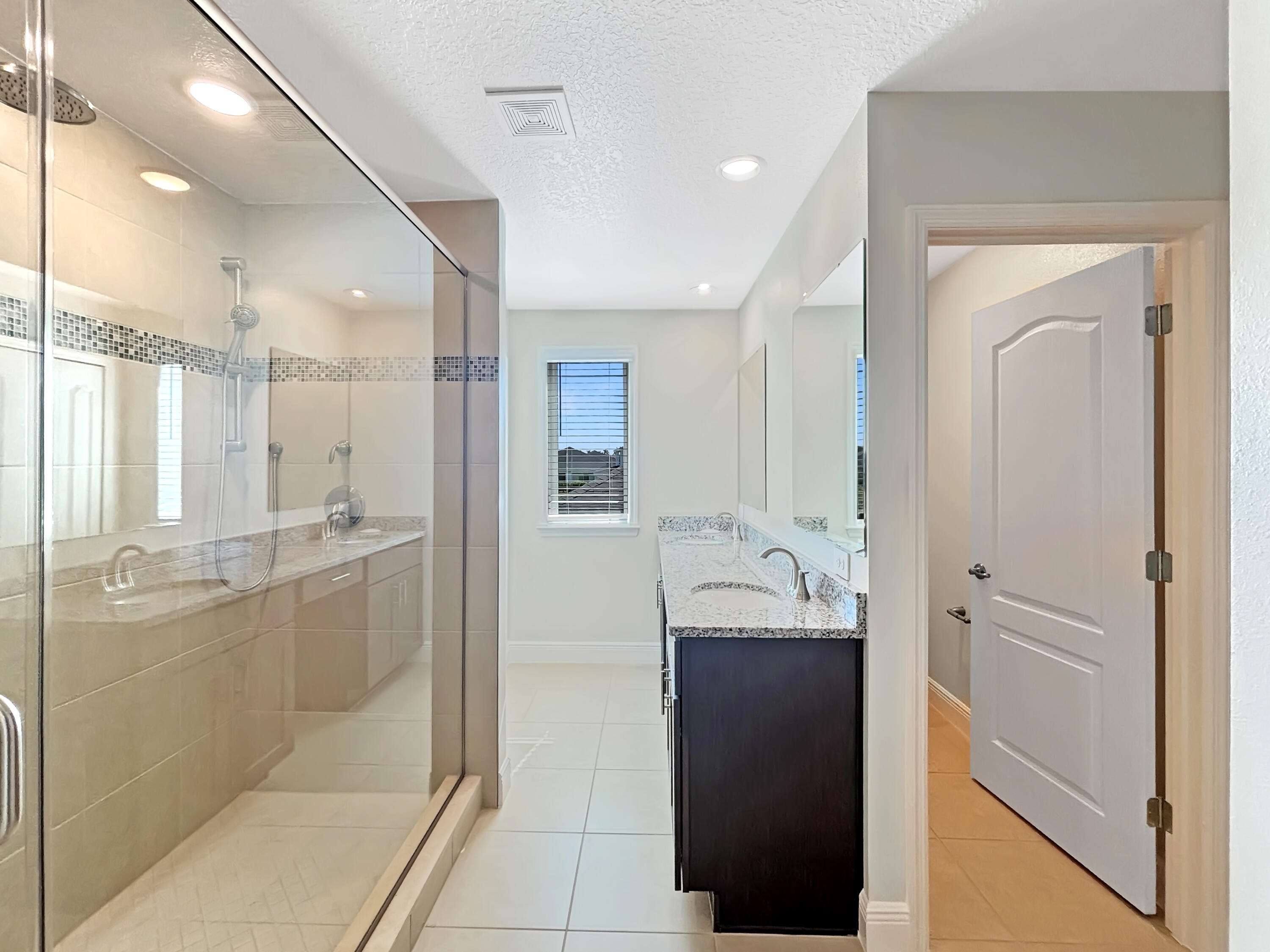 9399 Southwest Serapis Way Port Port St. Lucie, FL 34987 - Photo 38 of 43 a bathroom with a granite countertop sink mirror and a shower