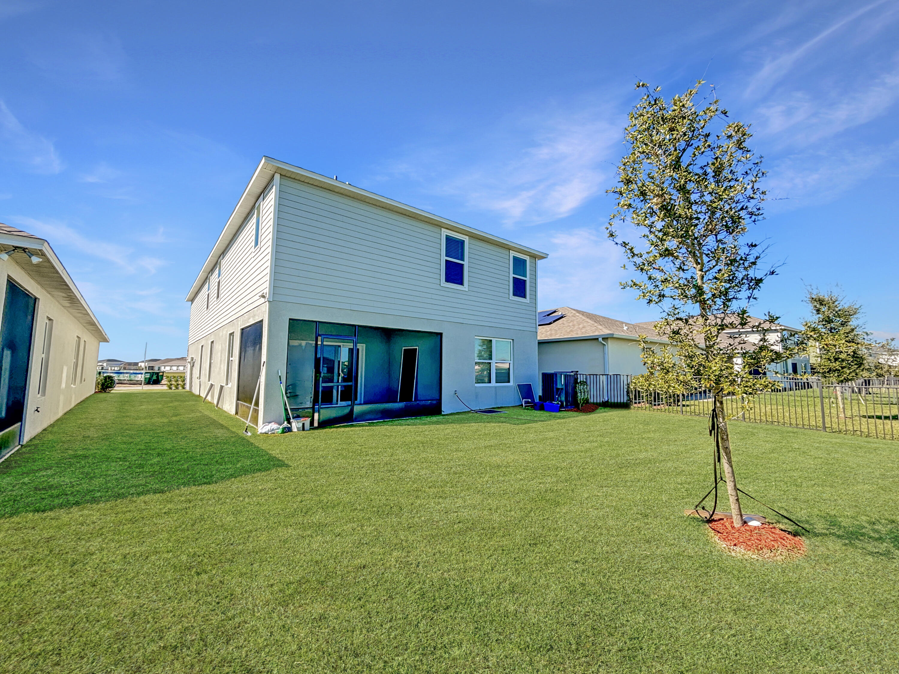 9399 Southwest Serapis Way Port Port St. Lucie, FL 34987 - Photo 43 of 43 a front view of house with a garden and trees