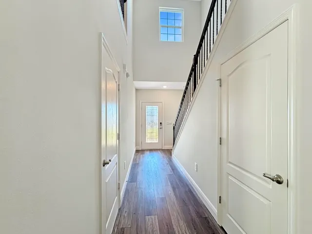 a view of a hallway with wooden floor and staircase