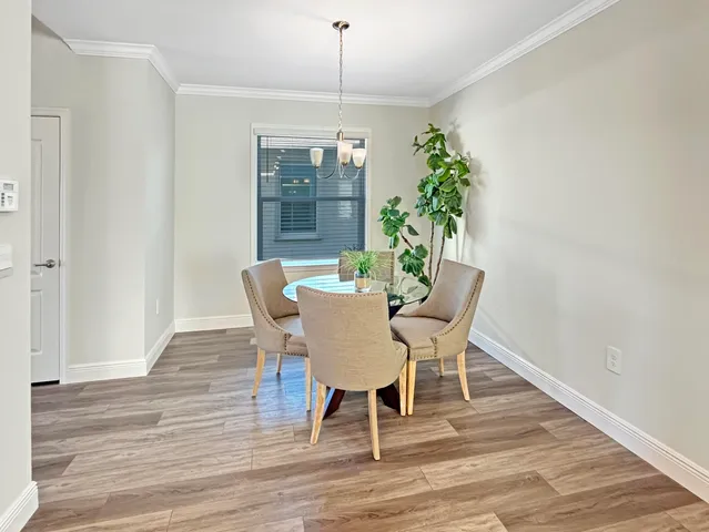 a dining room with furniture potted plants and wooden floor
