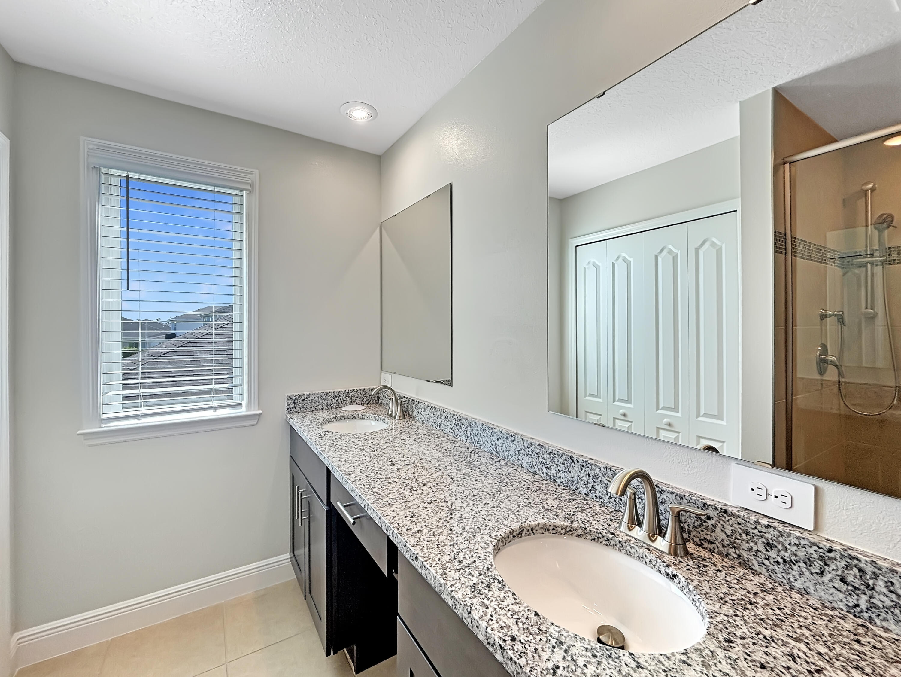 9399 Southwest Serapis Way Port Port St. Lucie, FL 34987 - Photo 8 of 43 a bathroom with a granite countertop double vanity sink and mirror