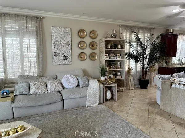 a living room with furniture a flat screen tv and a window