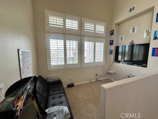 a bedroom with a bed window and flat screen tv