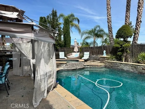 a view of a house with pool and sitting area
