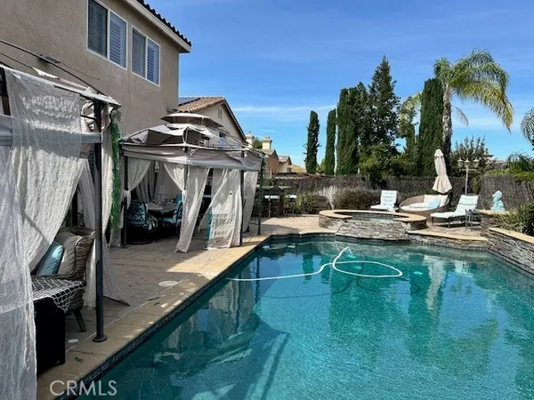 a view of a swimming pool with a patio and a lake view