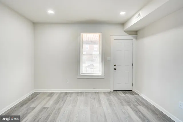 an empty room with wooden floor and window