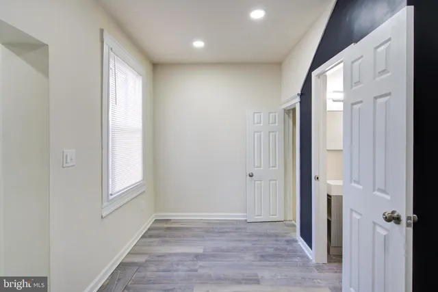 a view of a hallway with wooden floor and closet area