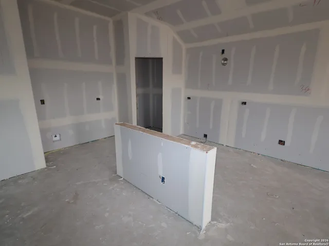 an empty room with a white cabinet and mirrors