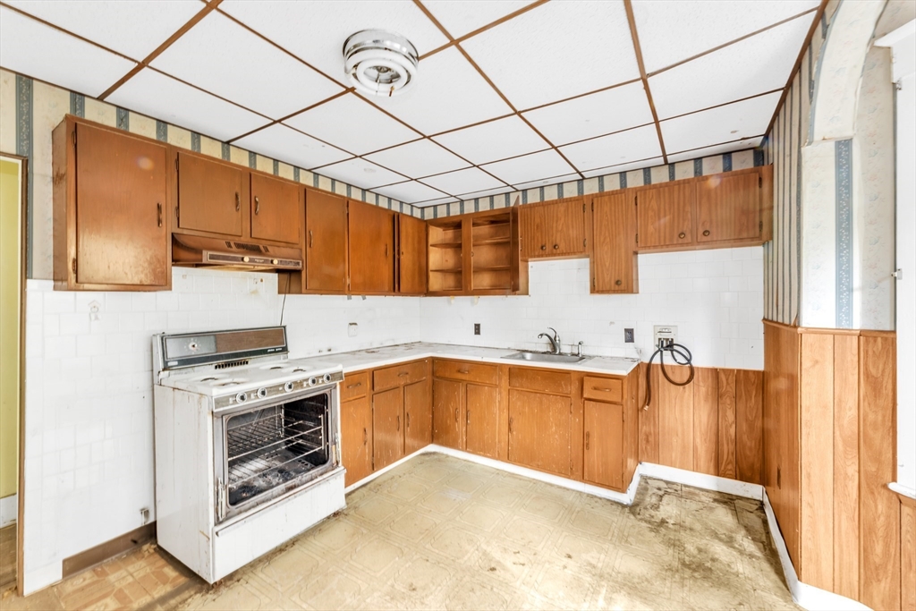 54 Oak Street Boston, MA 02136 - Photo 8 of 13 a kitchen with stainless steel appliances granite countertop a sink a stove and a wooden cabinets