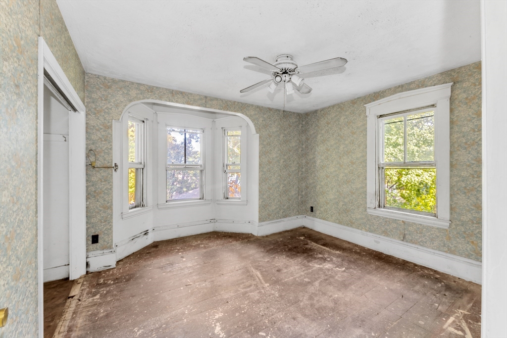 54 Oak Street Boston, MA 02136 - Photo 9 of 13 an empty room with windows and ceiling fan