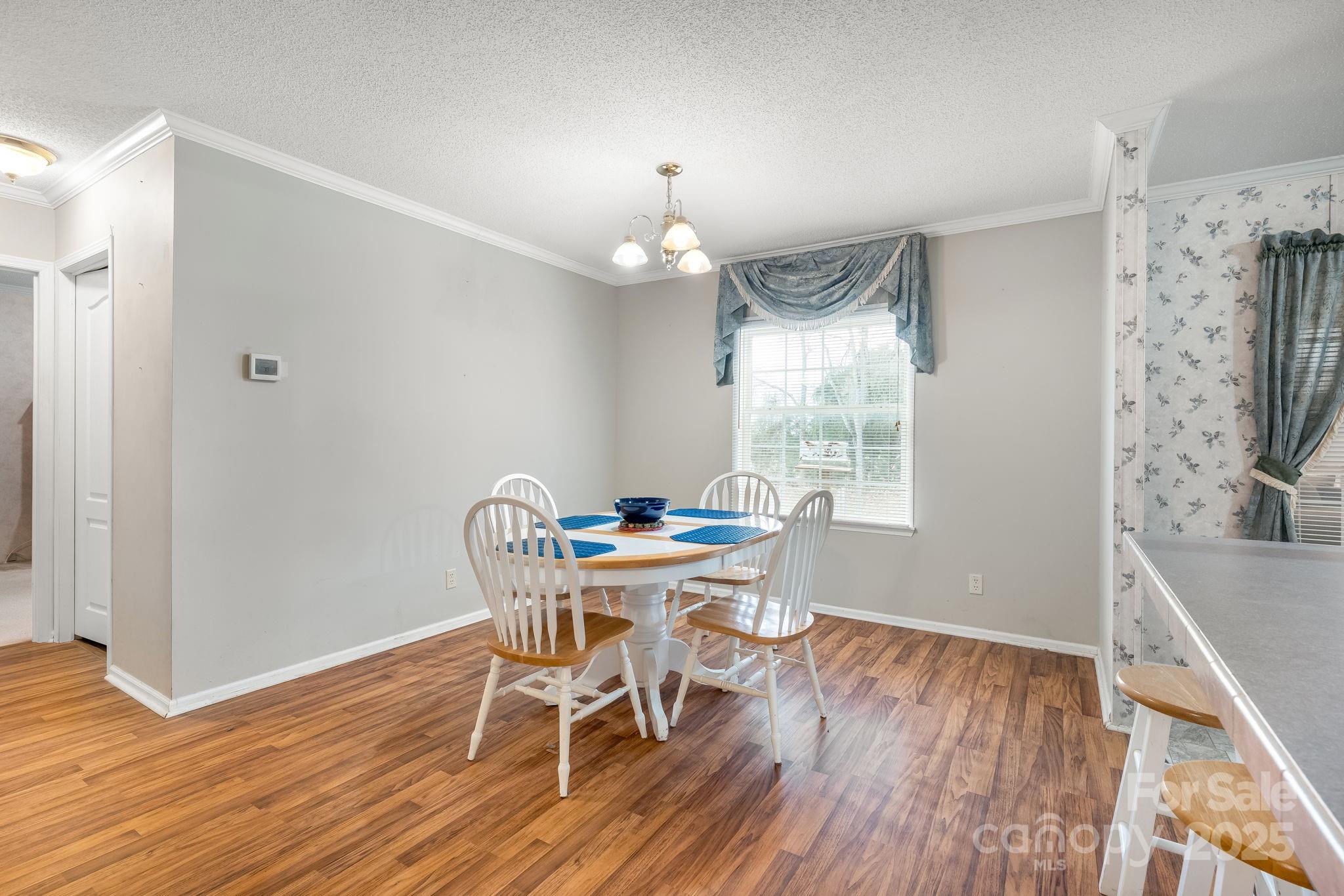 6351 Pleasant Grove Church Road Kannapolis, NC 28081 - Photo 8 of 21 a dining room with furniture a chandelier and wooden floor