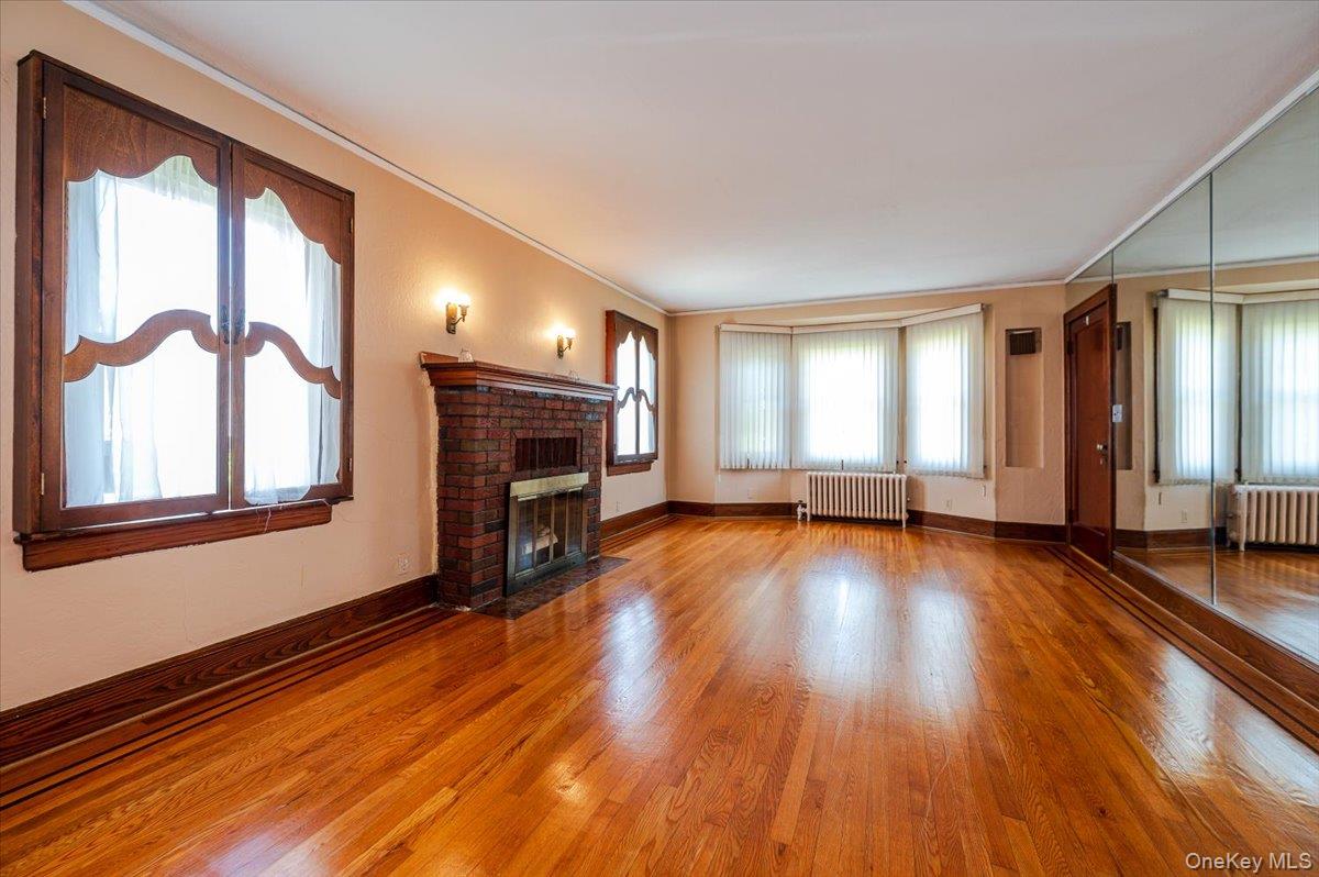 715 Iris Street Franklin Square, NY 11010 - Photo 2 of 20 a view of empty room with fireplace and wooden floor