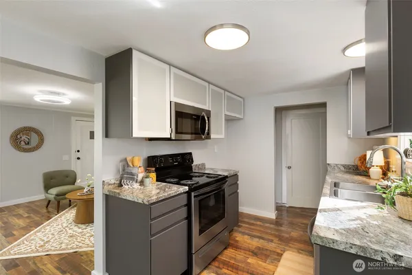 a kitchen with granite countertop a sink and a stove top oven