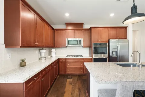 a kitchen with stainless steel appliances granite countertop a sink stove and refrigerator