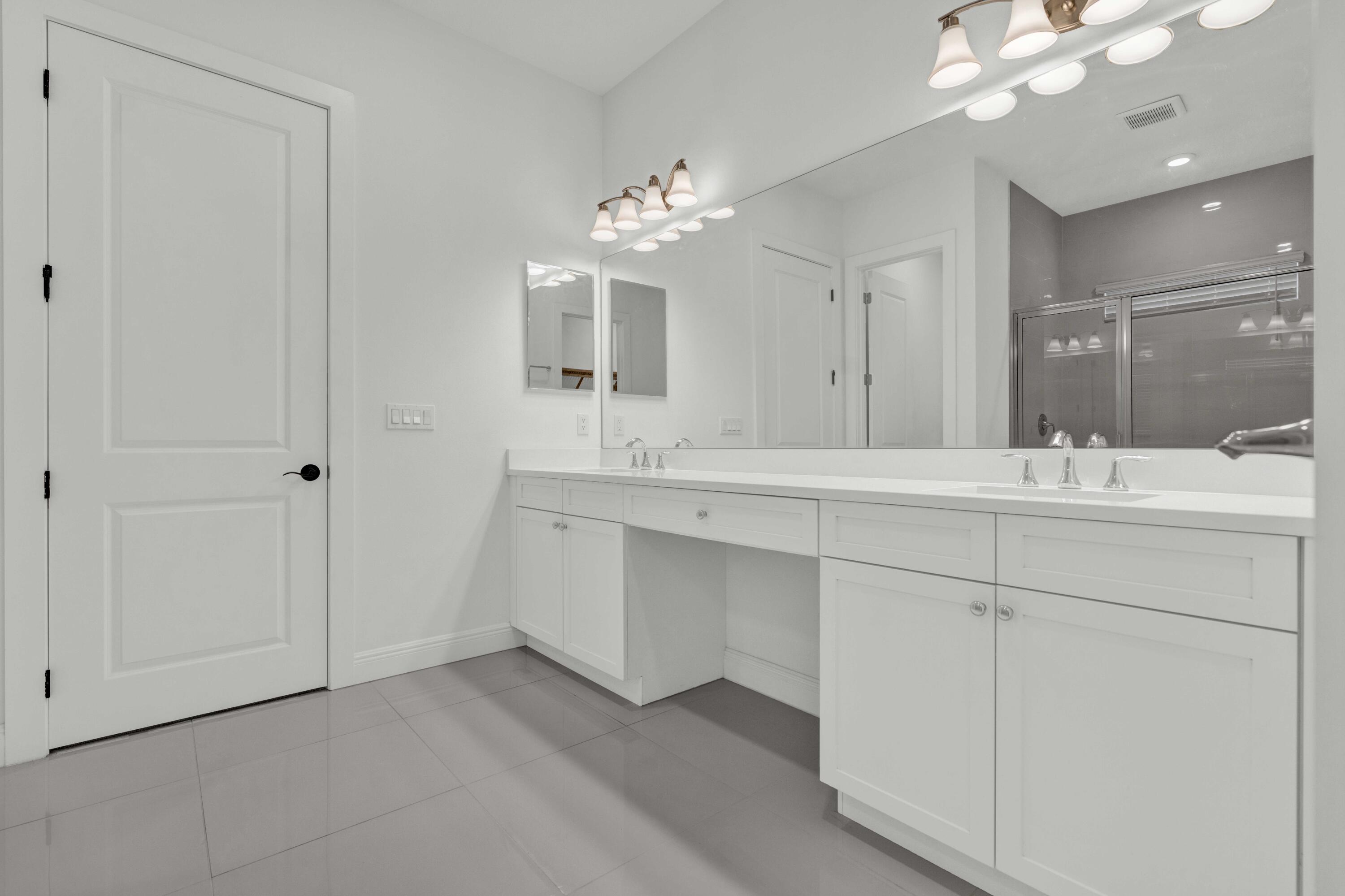 5501 Santa Rosa Lane Westlake, FL 33470 - Photo 21 of 31 a bathroom with a double vanity sink and a mirror