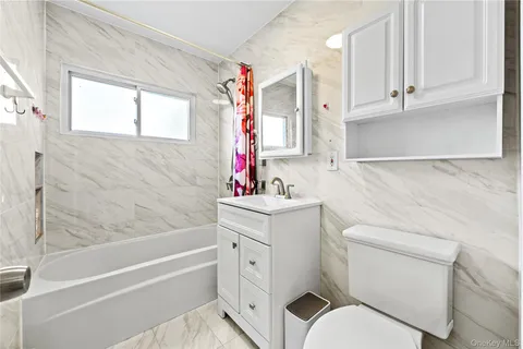 a bathroom with a sink toilet vanity and bathtub