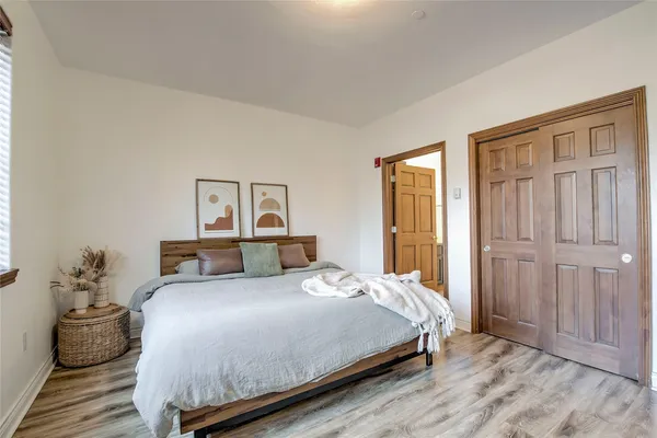 a bedroom with a bed and wooden floor