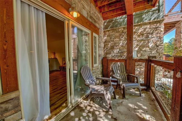 a view of a balcony with chairs and floor to ceiling window