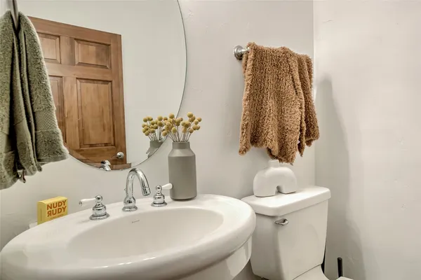 a bathroom with a sink toilet and mirror
