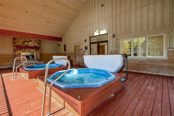 a room with furniture pool table windows and wooden floor