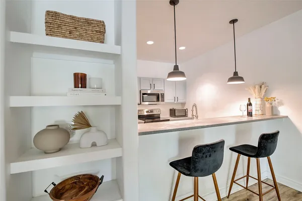 a kitchen with stainless steel appliances granite countertop a sink refrigerator and cabinets