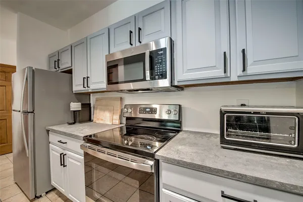 a kitchen with granite countertop white cabinets and stainless steel appliances