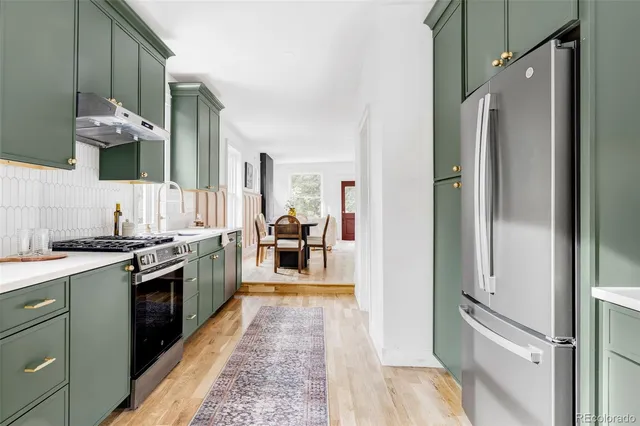 a kitchen with stainless steel appliances granite countertop a refrigerator and a sink