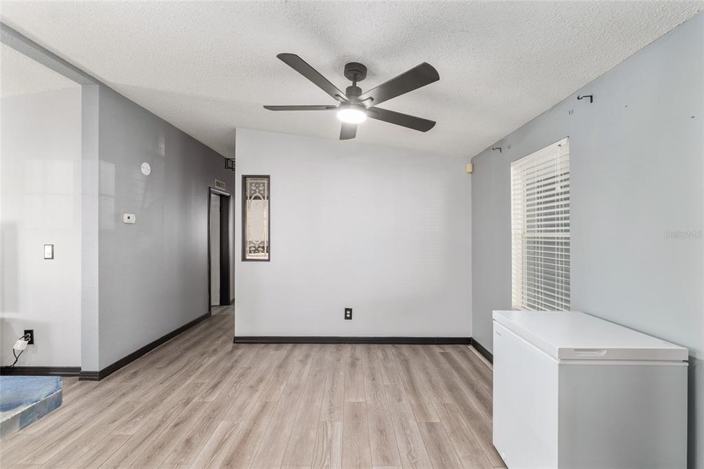6832 Northeast 3rd Place Ocala, FL 34470 - Photo 13 of 70 a view of an empty room with wooden floor and a window
