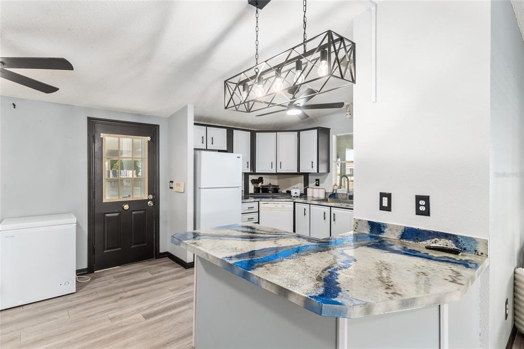 6832 Northeast 3rd Place Ocala, FL 34470 - Photo 18 of 70 a kitchen with kitchen island granite countertop a sink cabinets and wooden floor
