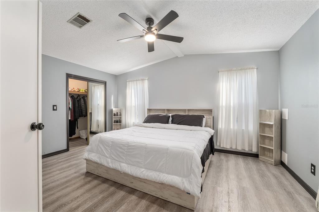 6832 Northeast 3rd Place Ocala, FL 34470 - Photo 28 of 70 a spacious bedroom with a bed and a chandelier