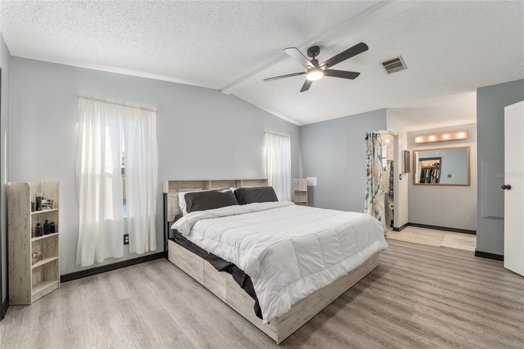 6832 Northeast 3rd Place Ocala, FL 34470 - Photo 29 of 70 a bedroom with a large bed and a chandelier