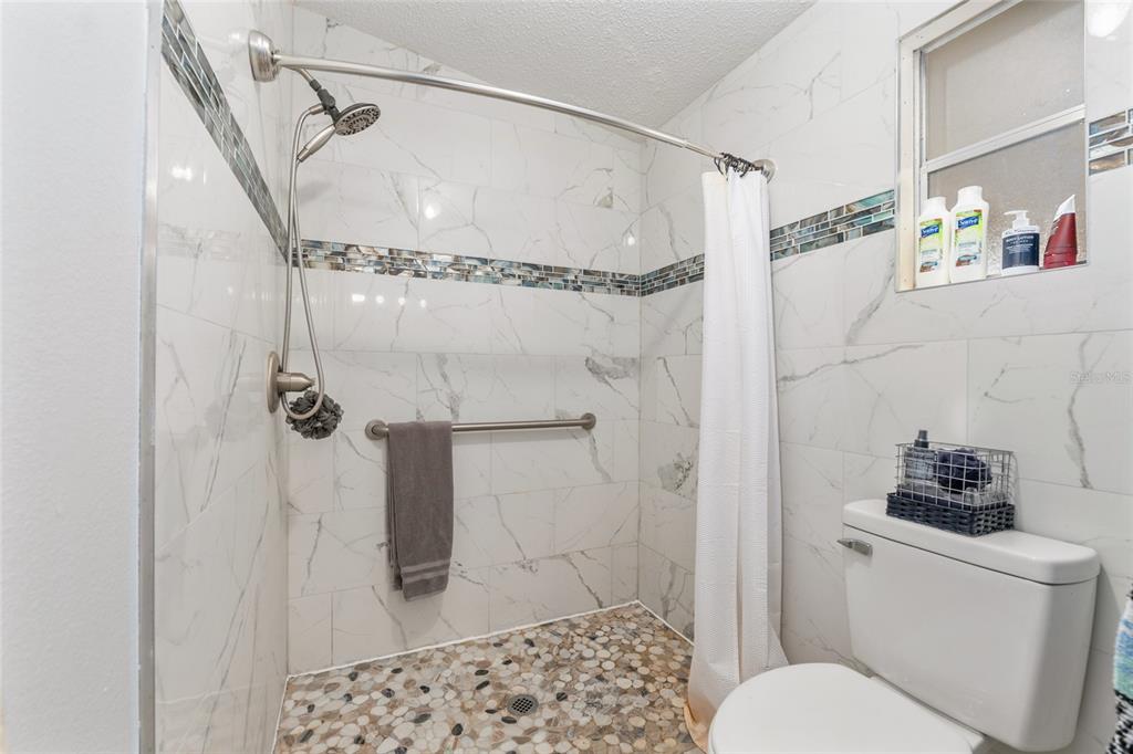 6832 Northeast 3rd Place Ocala, FL 34470 - Photo 33 of 70 a bathroom with a shower toilet and sink