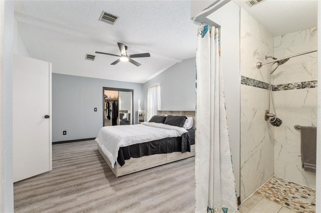 6832 Northeast 3rd Place Ocala, FL 34470 - Photo 34 of 70 a spacious bedroom with a bed and a chandelier