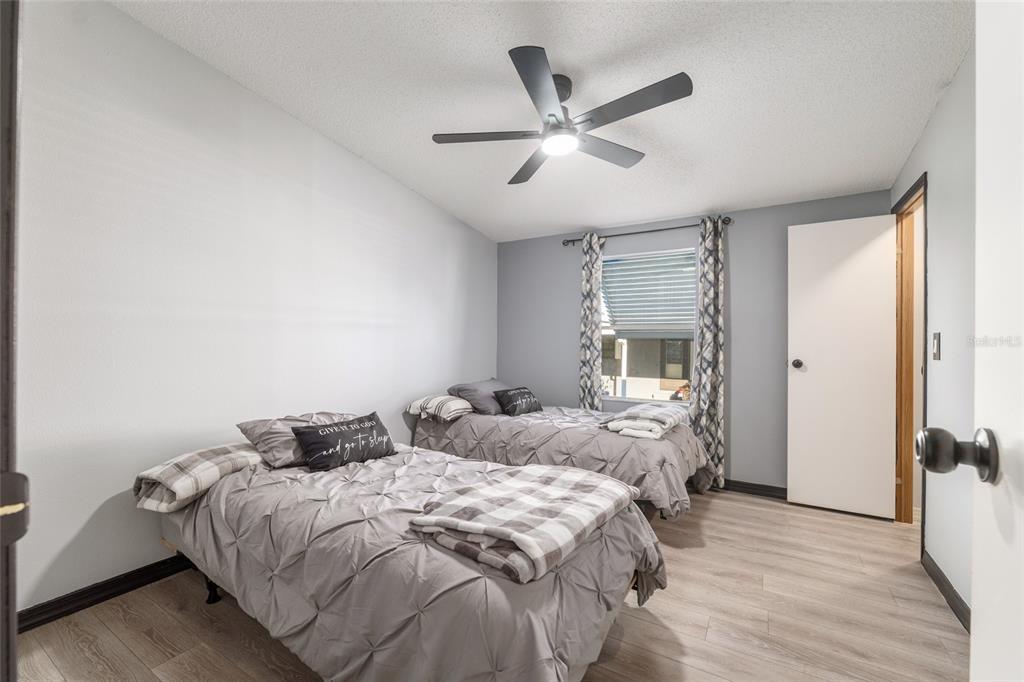 6832 Northeast 3rd Place Ocala, FL 34470 - Photo 36 of 70 a bedroom with a large bed and a chandelier