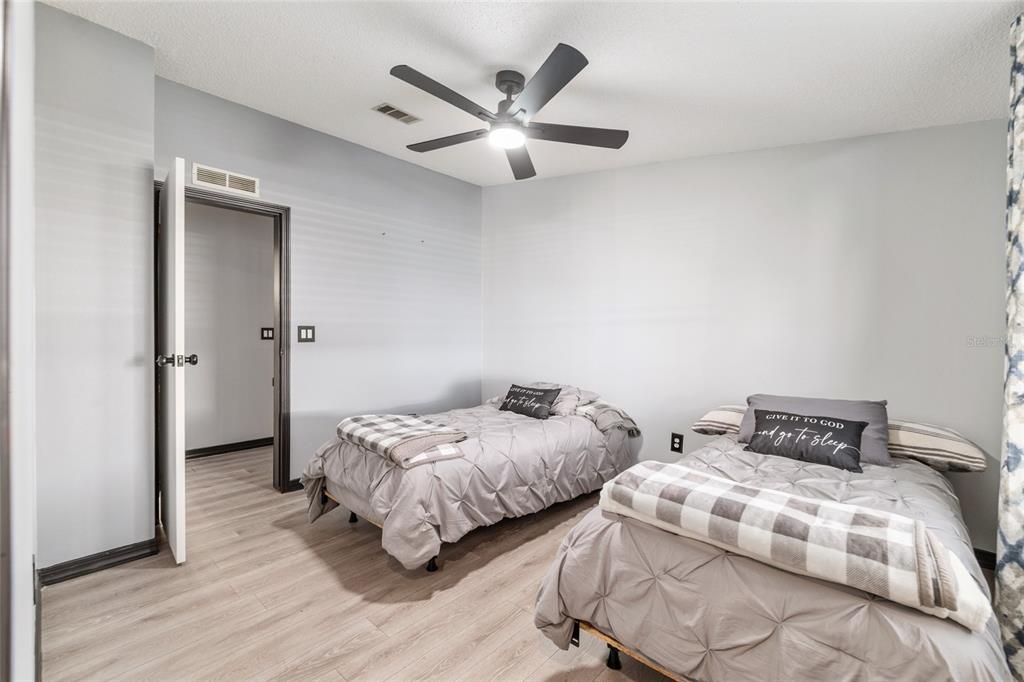 6832 Northeast 3rd Place Ocala, FL 34470 - Photo 38 of 70 a bedroom with two beds and a ceiling fan