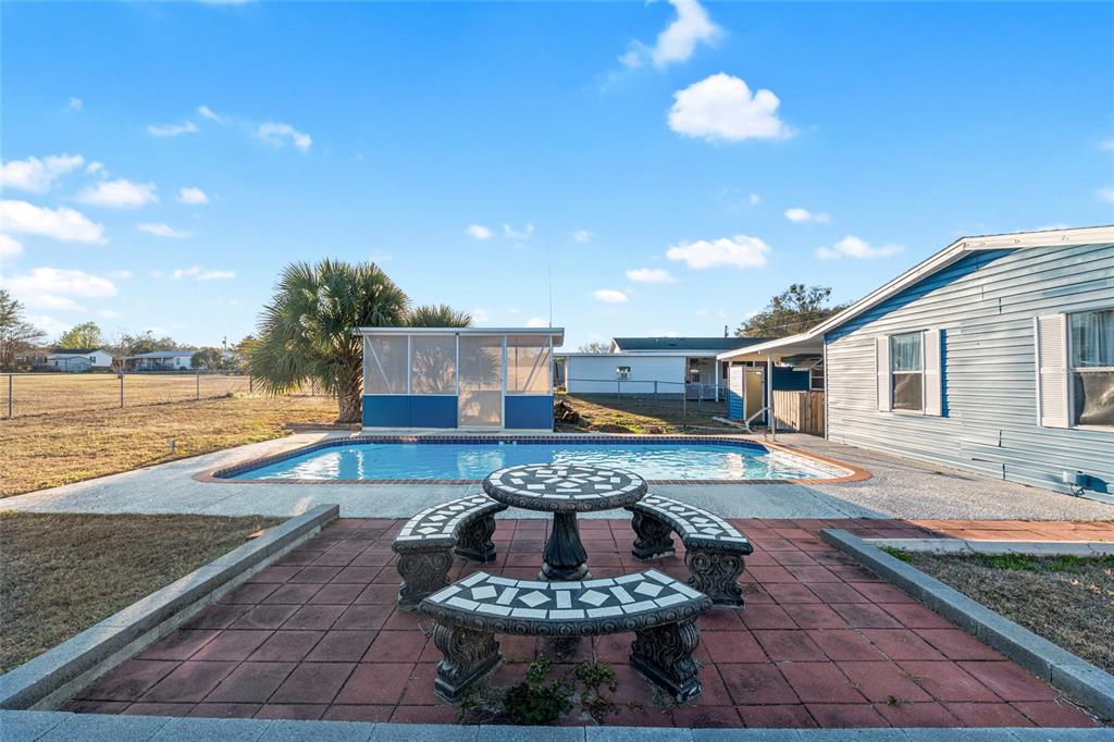 6832 Northeast 3rd Place Ocala, FL 34470 - Photo 52 of 70 a swimming pool with outdoor seating and yard