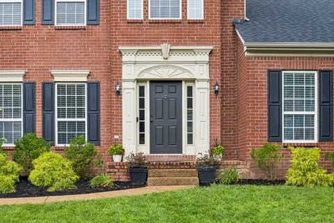 a front view of a house with a yard and outdoor seating
