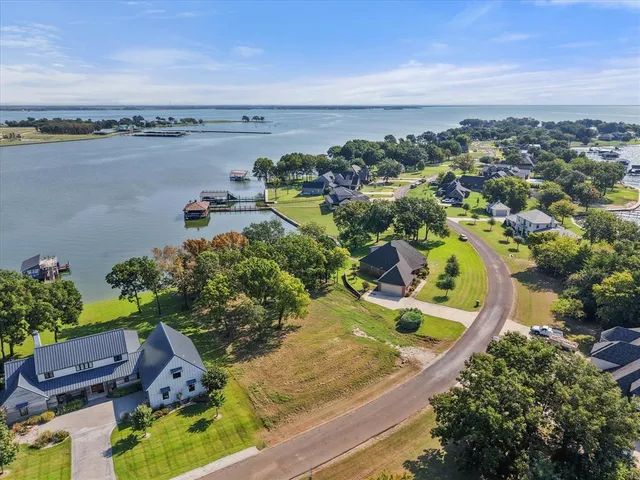 an aerial view of a house with a garden and lake view