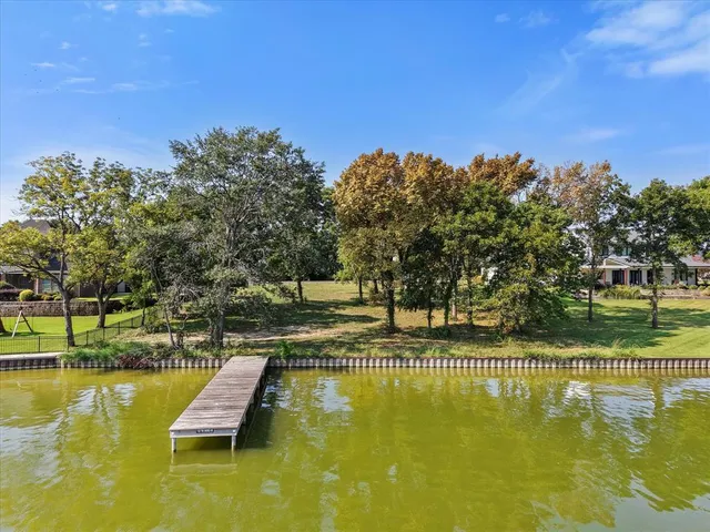a view of swimming pool with outdoor seating and trees in the background