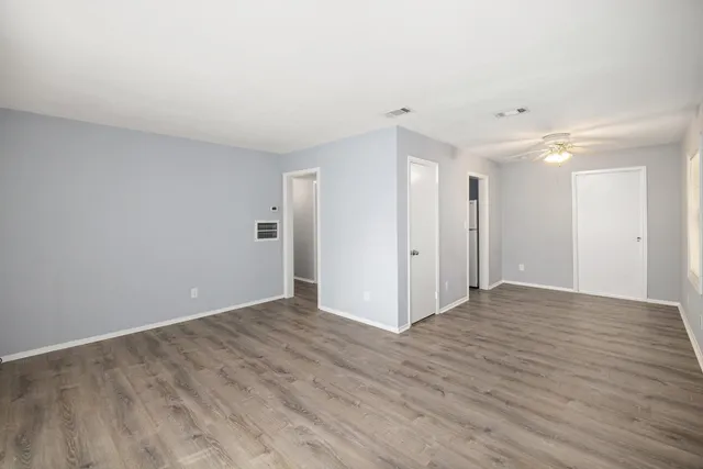 a view of an empty room with wooden floor