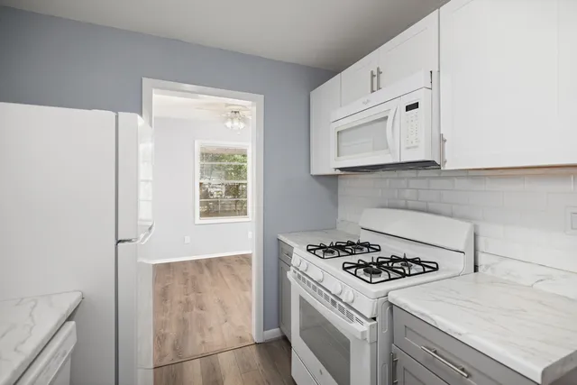 a kitchen with white cabinets and white appliances