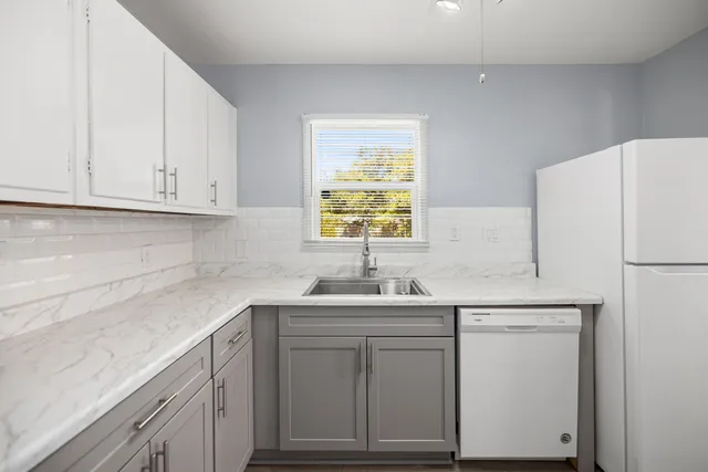 a kitchen with cabinets appliances a sink and a window