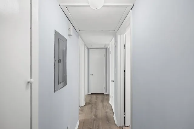 a view of a hallway with wooden floor and staircase